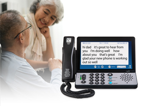 man and woman talking in background with 2400i phone in foreground
